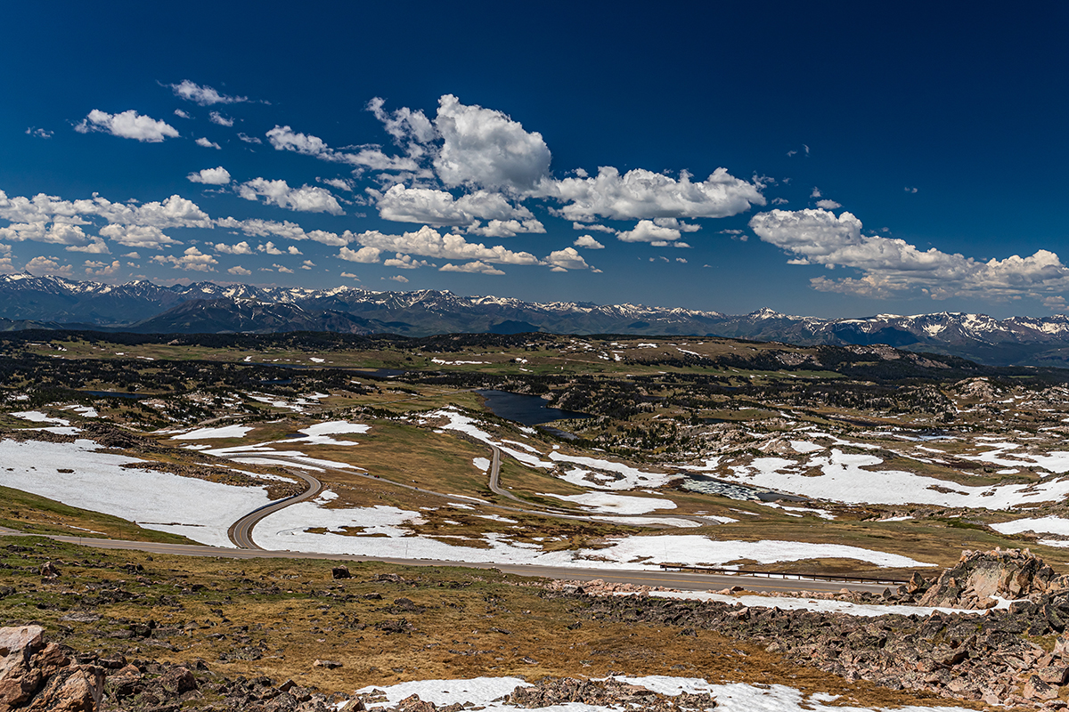 Aerial view of the Beartooth Highway winding through a snow covered alpine plateau on a day trip from Cody Wyoming