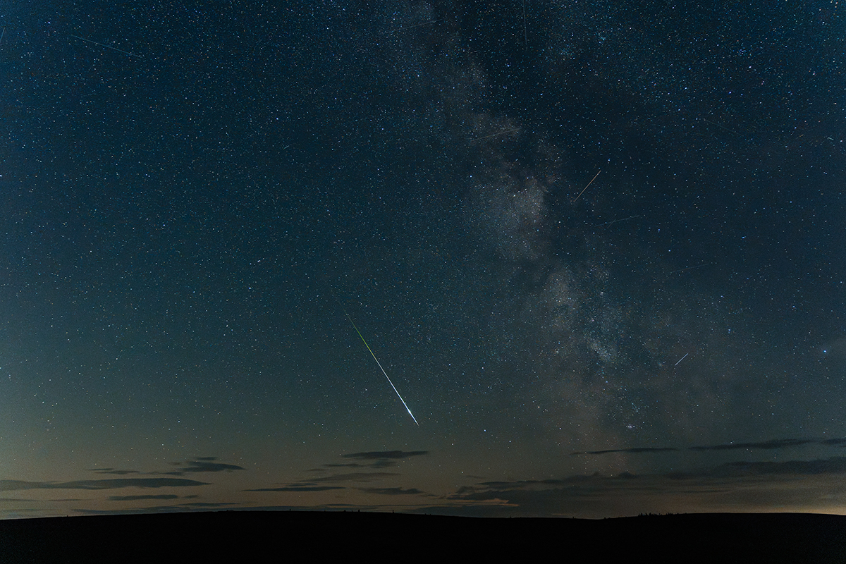 The Perseid Meteor Shower Near Yellowstone: Your Complete 2026 Guide 6 A single bright meteor streaking across a deep blue star filled sky during a Perseid meteor shower near Yellowstone