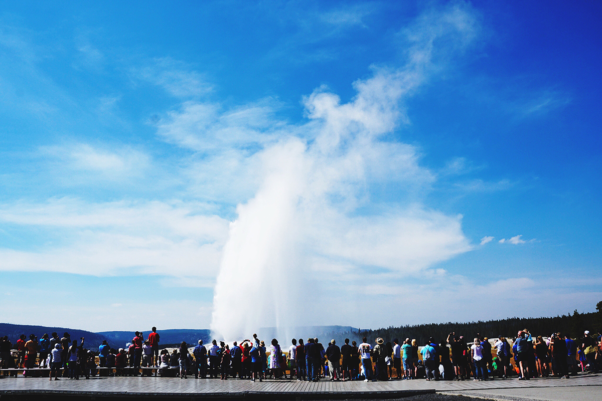 Yellowstone Group Camping: Why Old Faithful RV Park Is Perfect for Your Next Reunion or Rally 5 Old Faithful geyser erupting under a blue sky with scattered clouds
