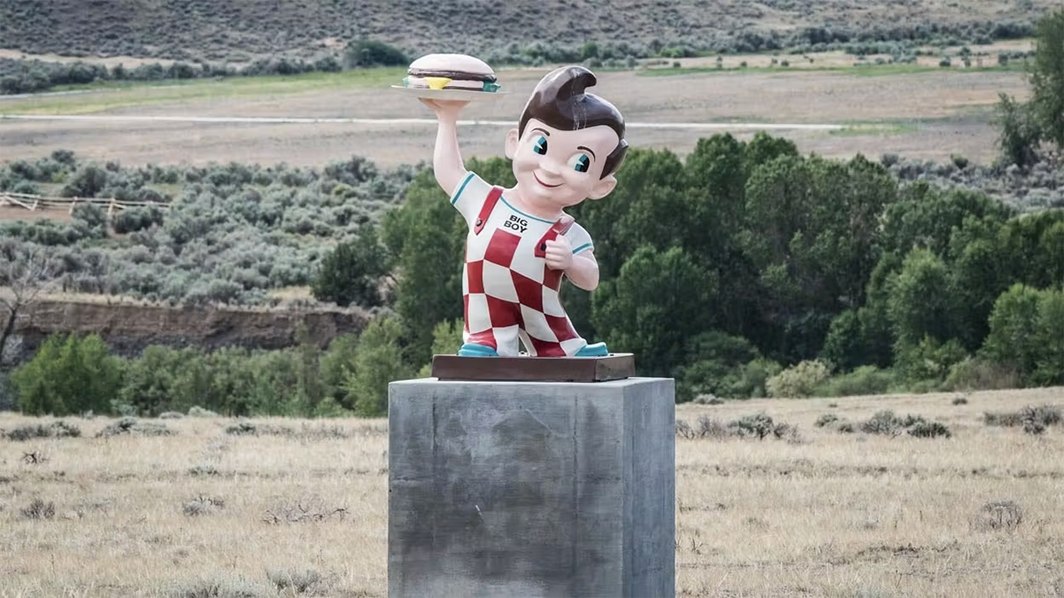 Big Boy statue on a concrete pedestal in a field along the highway near Cody Wyoming