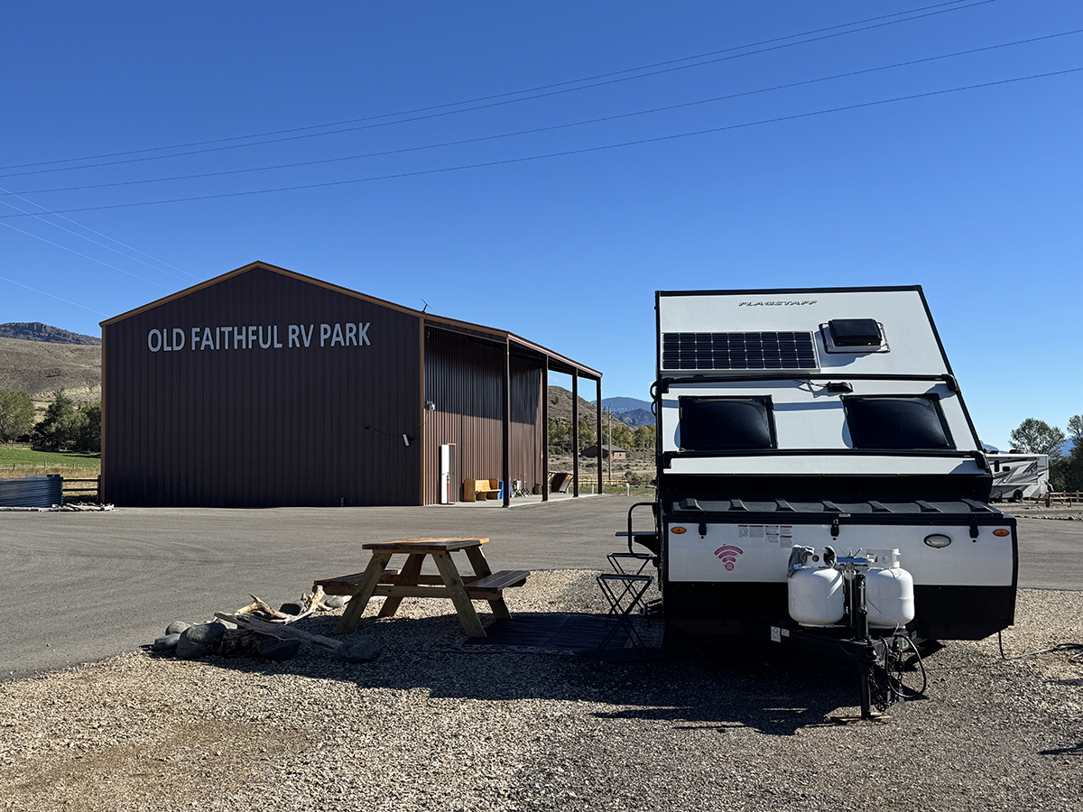Still Time This Season: Why Now Is a Great Time for a Late Season Yellowstone Trip 3 Small camper parked at a site with a picnic table under a clear fall sky at Old Faithful RV Park