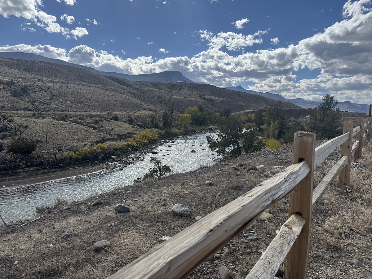 Camp Host Jobs Near Yellowstone: What Camp Hosting at Old Faithful RV Park Looks Like 11 North Fork Shoshone River beside a split rail fence with fall color, a view hosts enjoy on camp host jobs near Yellowstone