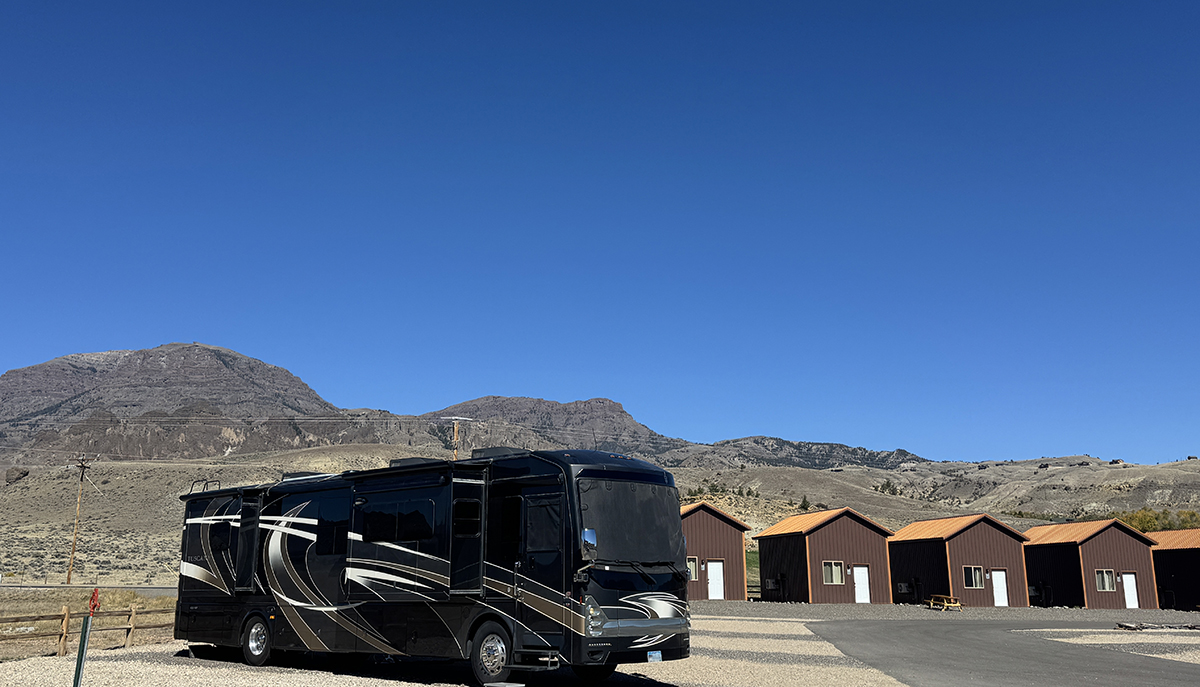 Camp Host Jobs Near Yellowstone: What Camp Hosting at Old Faithful RV Park Looks Like 7 Motorhome on a full hookup site beside cabins, home base for RV camp host jobs at Old Faithful RV Park